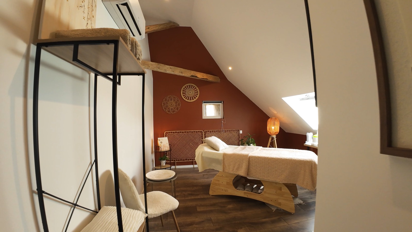 Salle de soin de l'Institut de Sidonie, mur terracotta et table de massage sous les combles